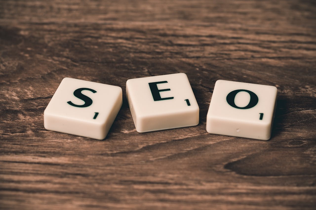 about-us Scrabble tiles spelling 'SEO' on a wooden surface. Ideal for digital marketing themes.