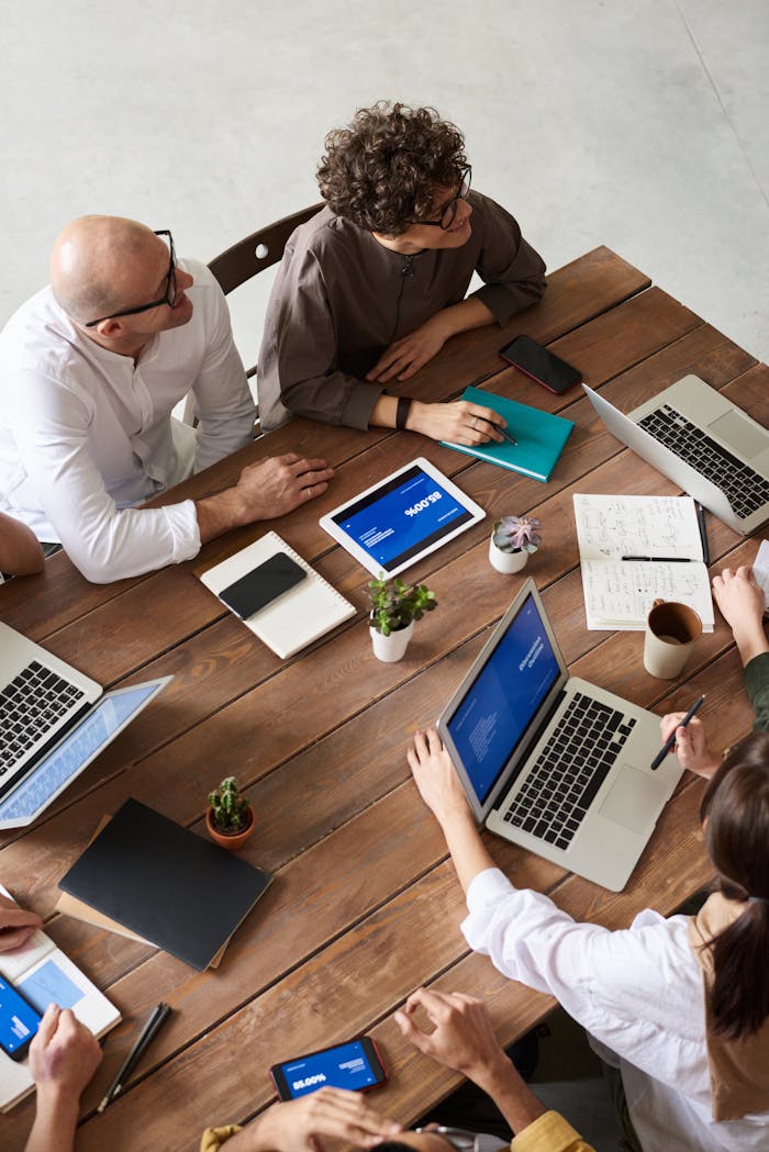 who-we-are High angle view of a diverse team in a modern office setting discussing a business project.