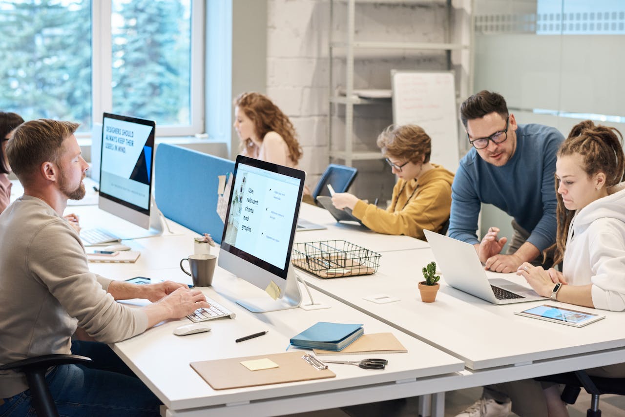 our-story Team collaboration in a modern office setting with computers and diverse employees working together.